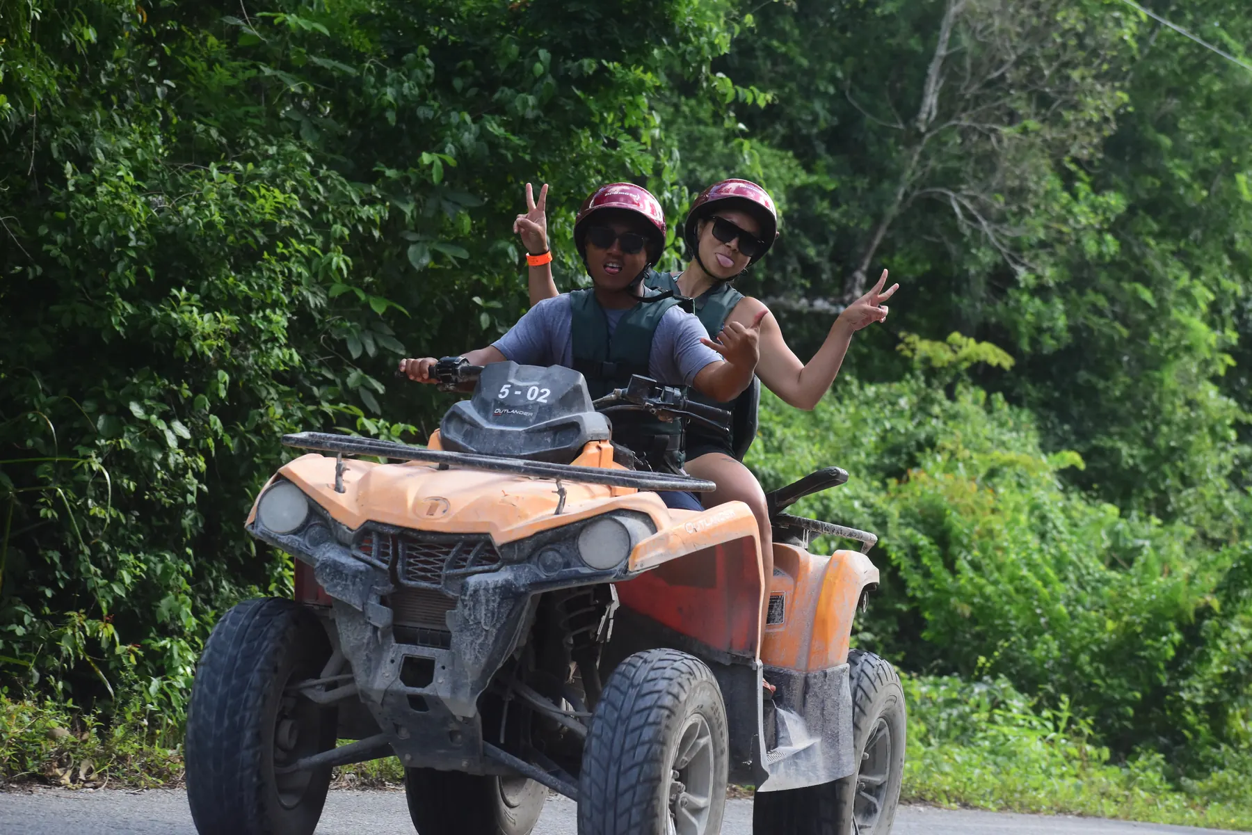 Helmeted guests riding an ATV through the Puerto Morelos jungle near Cancun